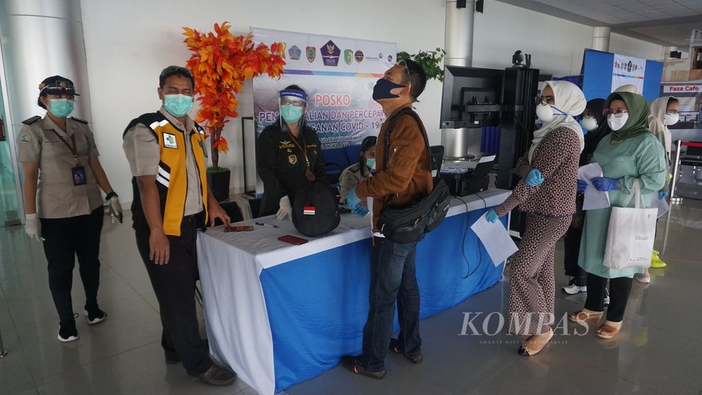 Calon penumpang Garuda Indonesia di Bandar Udara Tjilik Riwut, Kota Palangkaraya, Kalimantan Tengah, tujuan Jakarta sedang mengantre untuk diperiksa suhu tubuh juga kelengkapan administrasi lainnya, Selasa (12/5/2020).
