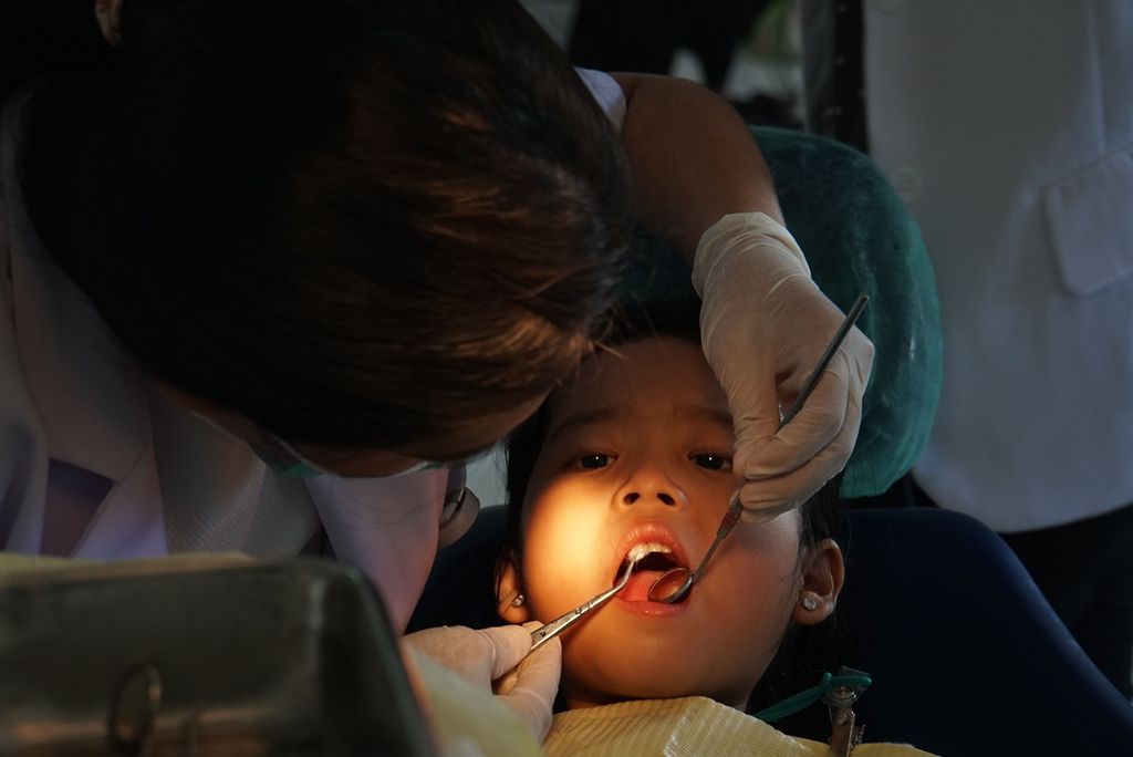 Seorang pasien anak-anak dengan gigi berlubang mendapatkan tindakan dari dokter gigi, Jumat (6/12/2019), di Rumah Sakit Gigi dan Mulut Universitas Sam Ratulangi Manado, Sulawesi Utara.