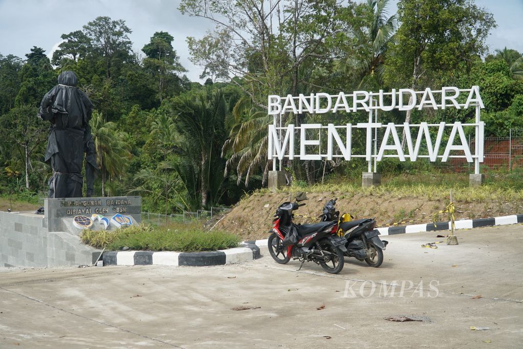 Patung sikerei dan plang nama di sekitar gerbang Bandara Mentawai di Dusun Rokot, Desa Matobe, Kecamatan Sipora Selatan, Kabupaten Kepulauan Mentawai, Sumatera Barat, Senin (24/7/2023).