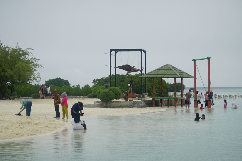 Wisatawan bermain di Pantai Pasir Perawan di Pulau Pari, Kabupaten Kepulauan Seribu, Jakarta, Senin (1/1/2024). Warga menjadikan pulau-pulau di kabupaten ini untuk menikmati libur akhir tahun dengan mandi dan bermain di pantai, <i>snorkeling</i>, dan menginap di tenda ataupun <i>homestay</i>. 