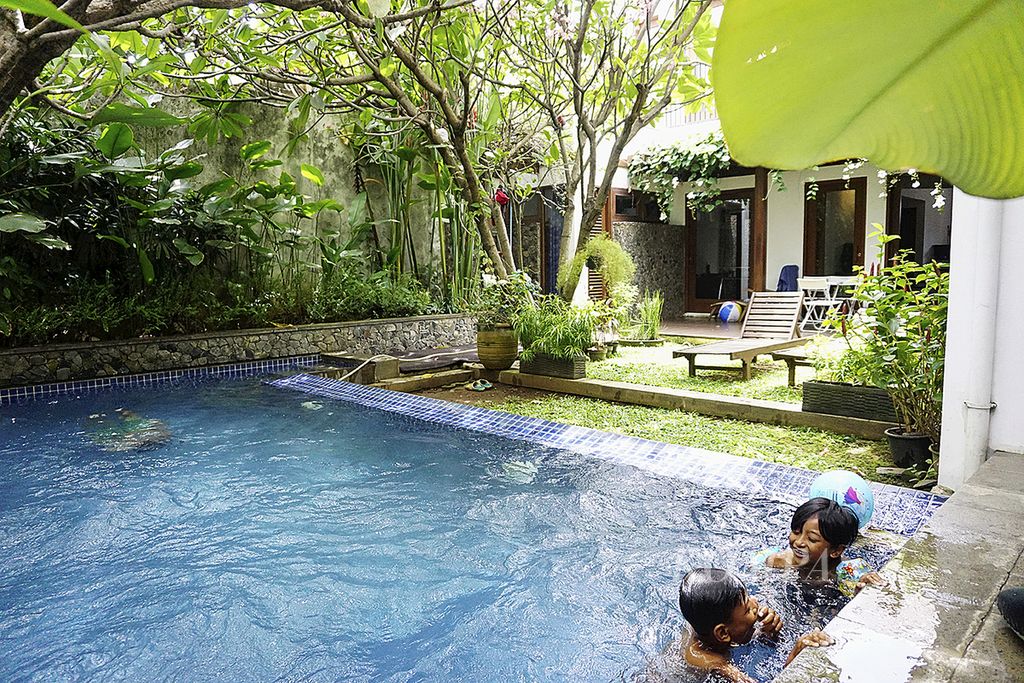 Wisatawan sedang berenang di kolam renang di sebuah rumah yang disewakan untuk wisatawan melalui aplikasi Airbnb, di Jakarta, Jumat (23/12/2016). Lewat aplikasi ini, pelancong dapat memilih rumah atau apartemen yang hendak disewa secara daring. 