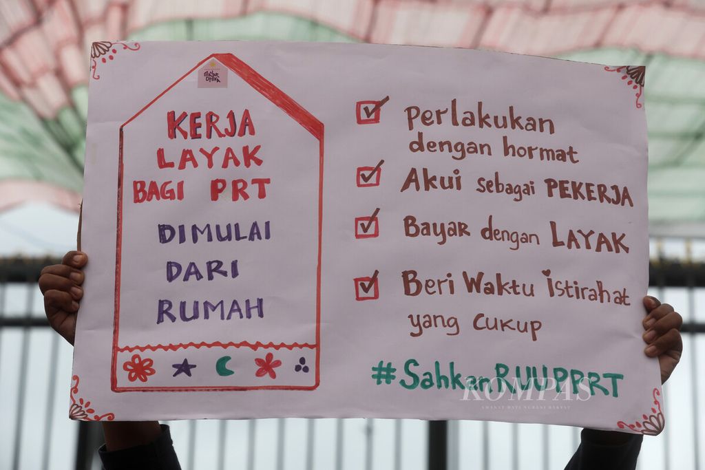 Peserta unjuk rasa membawa poster aspirasi mereka dalam aksi memperingati Hari Pekerja Rumah Tangga di depan kompleks gedung Parlemen, Jakarta, Rabu (15/2/2023). 