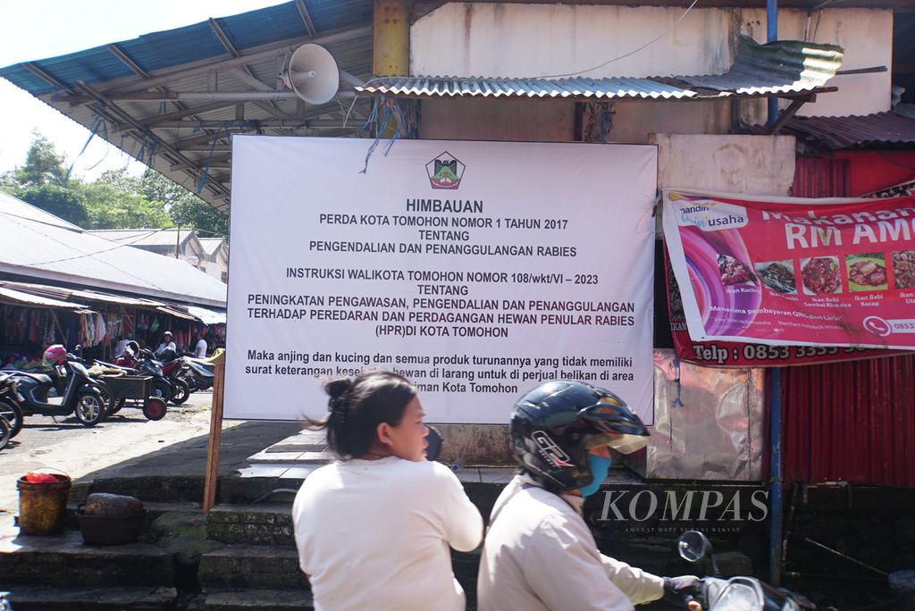 Sebuah spanduk dipasang di Pasar Beriman Wilken, Tomohon, Sulawesi Utara, Selasa (25/7/2023), untuk mencegah penularan rabies melalui daging hewan. Pemerintah Kota Tomohon telah melarang penjualan daging anjing dan kucing sejak 21 Juli 2023 berdasarkan kesepakatan dengan sebuah lembaga swadaya masyarakat internasional.