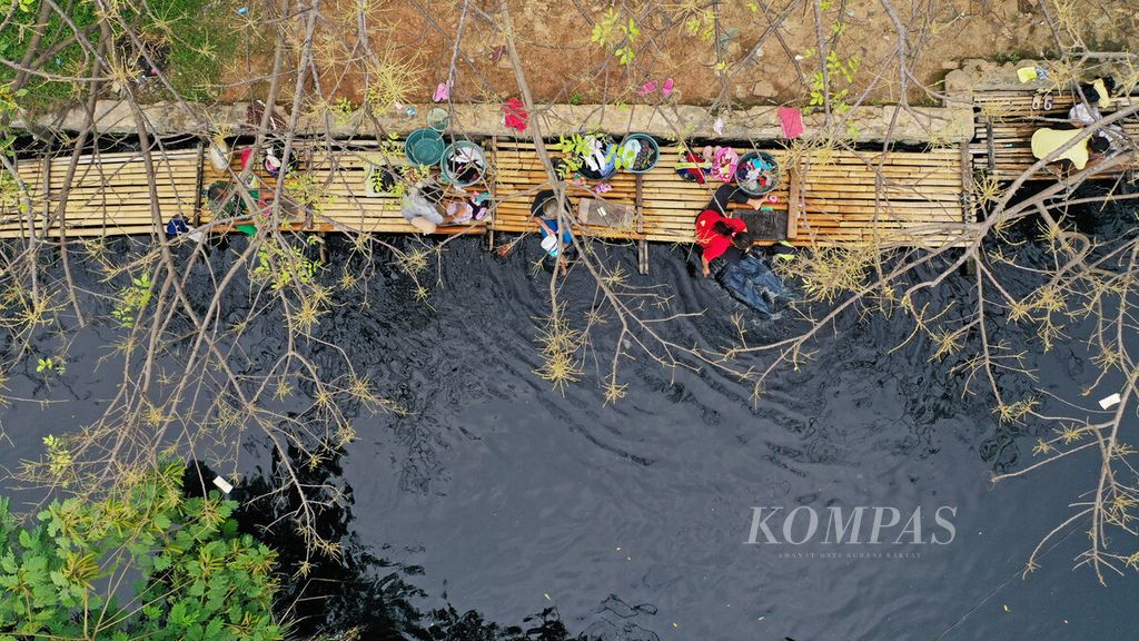 Warga mencucui pakaian di aliran Kali Cilemahabang yang airnya berwarna hitam pekat di Desa Sukaraya, Kecamatan Karangbahagia, Kabupaten Bekasi, Jawa Barat, Selasa (6/9/2021). Pencemaran aliran sungai yang airnya berwarna hitam pekat tersebut diduga dari pembuangan limbah industri. 