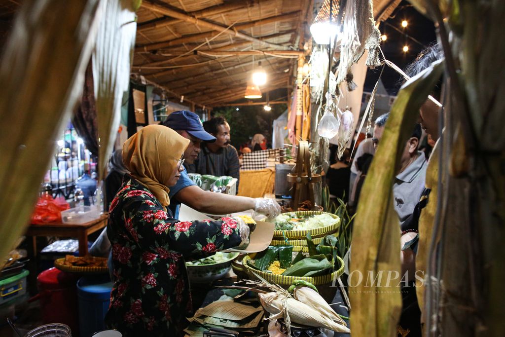 Pedagang Sego Jagung melayani pembeli dengan di Pasar Kangen Jogja 2023 di Taman Budaya Yogyakarta, Kota Yogyakarta, Rabu (2/8/2023) malam. 
