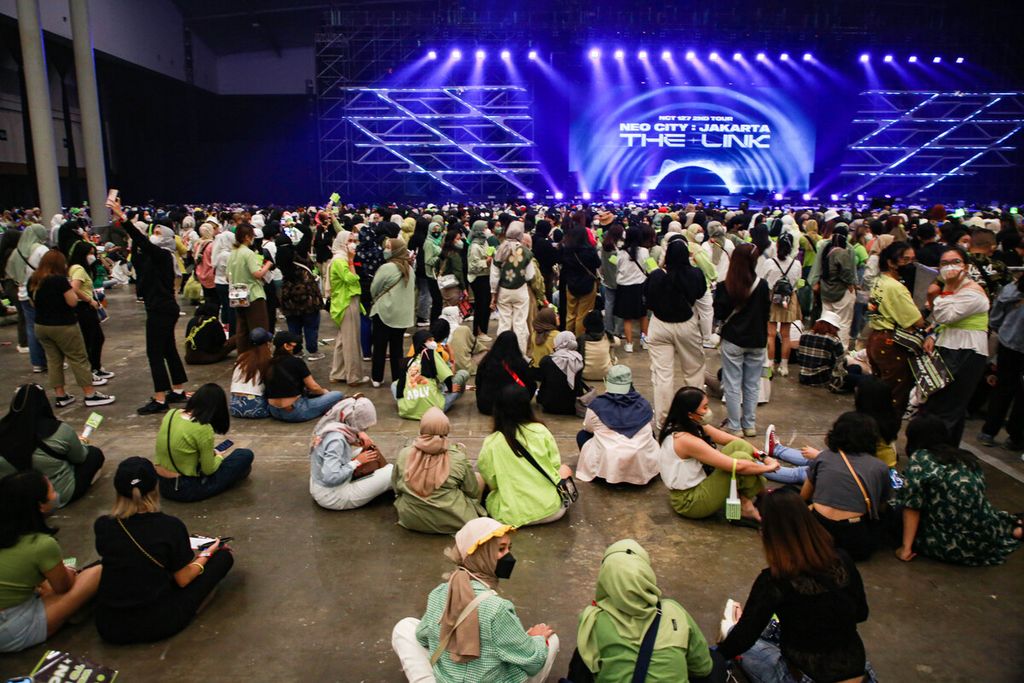 Para NCTzen yang sebagian besar adalah remaja putri duduk lesehan sambil menunggu konser NCT 127 di Indonesia Convention Exhibition (ICE), BSD City, Kabupaten Tangerang, Banten, Jumat (4/11/2022) malam. 