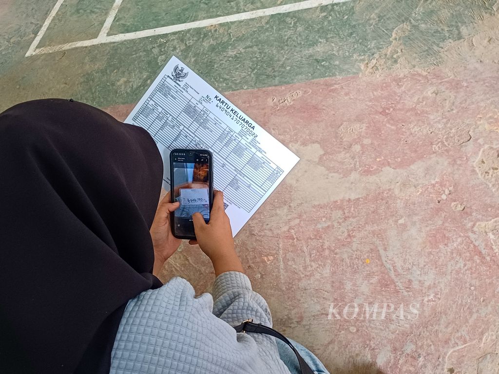 Warga menunggu namanya dipanggil saat mengantre untuk menerima nilai ganti rugi lahan, tanaman, dan bangunan yang terdampak pembangunan jalan bebas hambatan seksi 6B, salah satu proyek Ibu Kota Nusantara atau IKN di Kelurahan Pemaluan, Kecamatan Sepaku, Penajam Paser Utara, Kalimantan Timur, Rabu (14/8/2024).