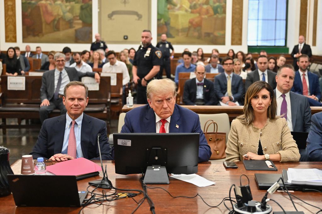 Mantan Presiden AS Donald Trump (tengah) menghadiri hari ketiga persidangan penipuan sipil di New York pada 4 Oktober 2023. Pada 16 Februari 2024, pengadilan menjatuhkan denda atas dakwaan penipuan sebesar Rp 5,6 triliun.  