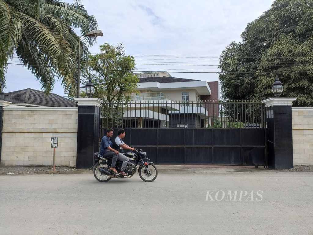 Warga melintas di depan rumah pribadi Bupati Langkat Terbit Rencana Perangin-Angin, di Desa Raja Tengah, Kecamatan Kuala, Kabupaten Langkat, Sumatera Utara, Selasa (25/1/2022).
