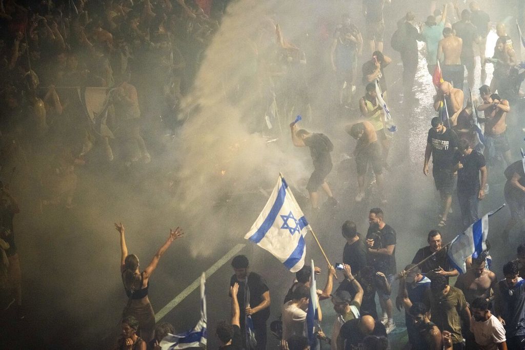 Polisi menggunakan menyemprotkan air untuk membubarkan para pengunjuk rasa yang menolak reformasi hukum pemerintahan Perdana Menteri Benyamin Netanyahu, Senin (24/7/2023) di Tel Aviv, Israel.