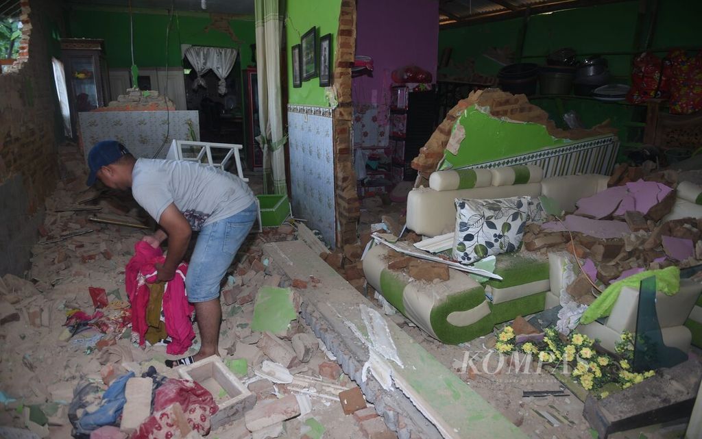 Ahmad Rifae mengumpulkan barang-barang yang bisa diselamatkan dari dalam rumahnya yang rusak berat pascagempa di Desa Dekat Agung, Kecamatan Sangkapura, Pulau Bawean, Kabupaten Gresik, Minggu (24/3/2024). 