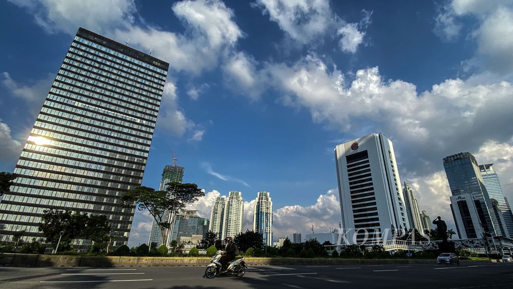 Pantulan sinar matahari di gedung tinggi di Jakarta yang berlangit biru. 