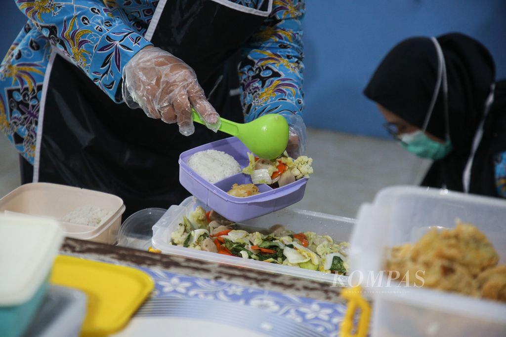 Petugas mempersiapkan makan siang pada kegiatan simulasi program makan siang gratis untuk siswa di SMP Negeri 2 Curug, Kabupaten Tangerang, Banten, Kamis (29/2/2024). Sebanyak 160 porsi makan siang gratis dipersiapkan bagi siswa pada kesempatan tersebut.