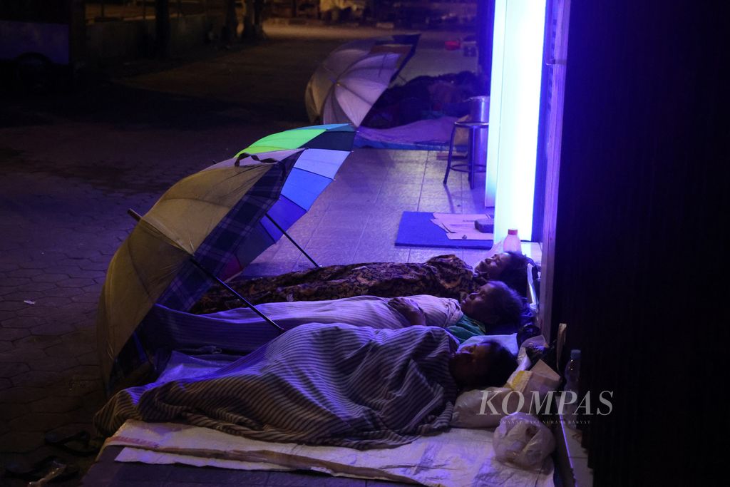 Several female porters slept in front of a bank opposite Beringharjo Market, Yogyakarta, Tuesday (7/3/2023) early morning. Porters in the market each earn around IDR 50,000 per day from helping move goods belonging to traders or buyers.