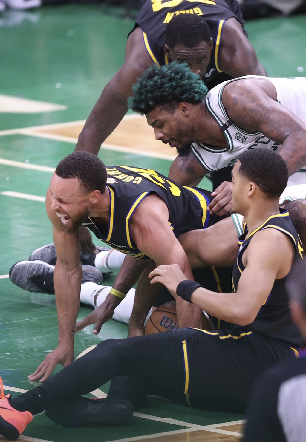 Bintang Golden State Warriors, Stephen Curry (kiri), mengerang kesakitan setelah kaki kirinya tertimpa pemain Boston Celtics, Al Horford (kanan), pada kuarter keempat gim ketiga seri final NBA di Boston, Rabu (8/6/2022) lalu waktu setempat. 