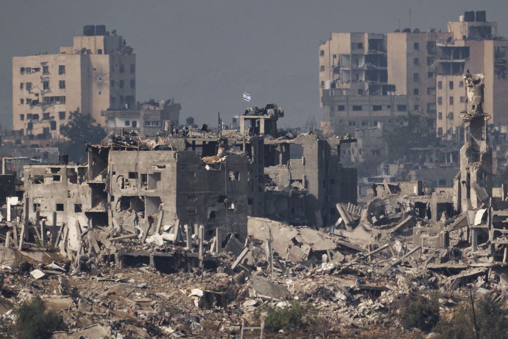 Sebuah bendera terpasang di atas bangunan yang rusak akibat serangan militer Israel di kota Gaza, Rabu (15/11/2023). Militer Israel menyatakan bahwa mereka telah menguasai Gaza utara. 