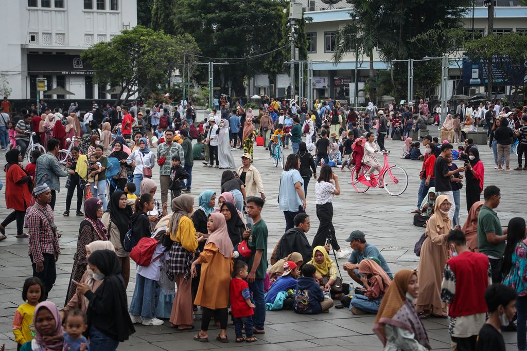 Kerumunan wisatawan di kawasan Kota Tua, Jakarta, Minggu (23/4/2023). Kawasan Kota Tua dipadati wisatawan saat libur Lebaran. Di kawasan tersebut, wisatawan dapat menikmati suasana dengan duduk bersantai, menonton pentas musik, dan menyewa sepeda untuk berkeliling. 