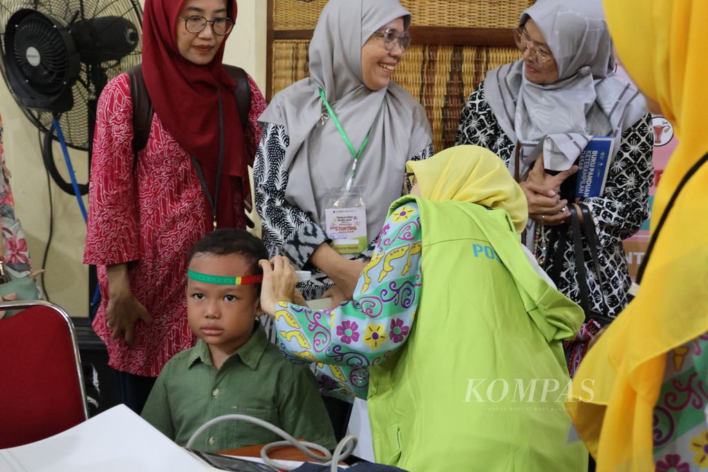 Warga membawa putra-putrinya yang masih balita ke Posyandu Wijaya Kusuma, Kota Bogor, Jawa Barat, Selasa (11/6/2024).