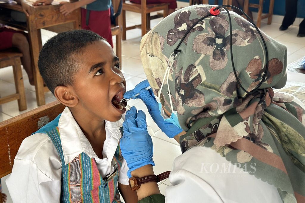Siswa Sekolah Dasar Inpres Nenonaheun, Kecamatan Mollo Selatan, Kabupaten Timor Tengah Selatan, Nusa Tenggara Timur, mengikuti pemeriksaan gigi yang diselenggarakan Plan Indonesia, Kamis (27/10/2023). 