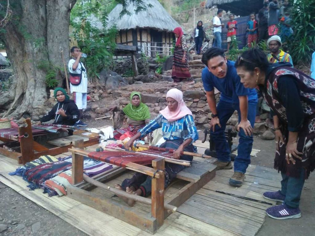 Syariat Libaba (kanan) memperhatikan anggota kelompok binaannya menenun di Pulau Buaya, Kabupaten Alor.