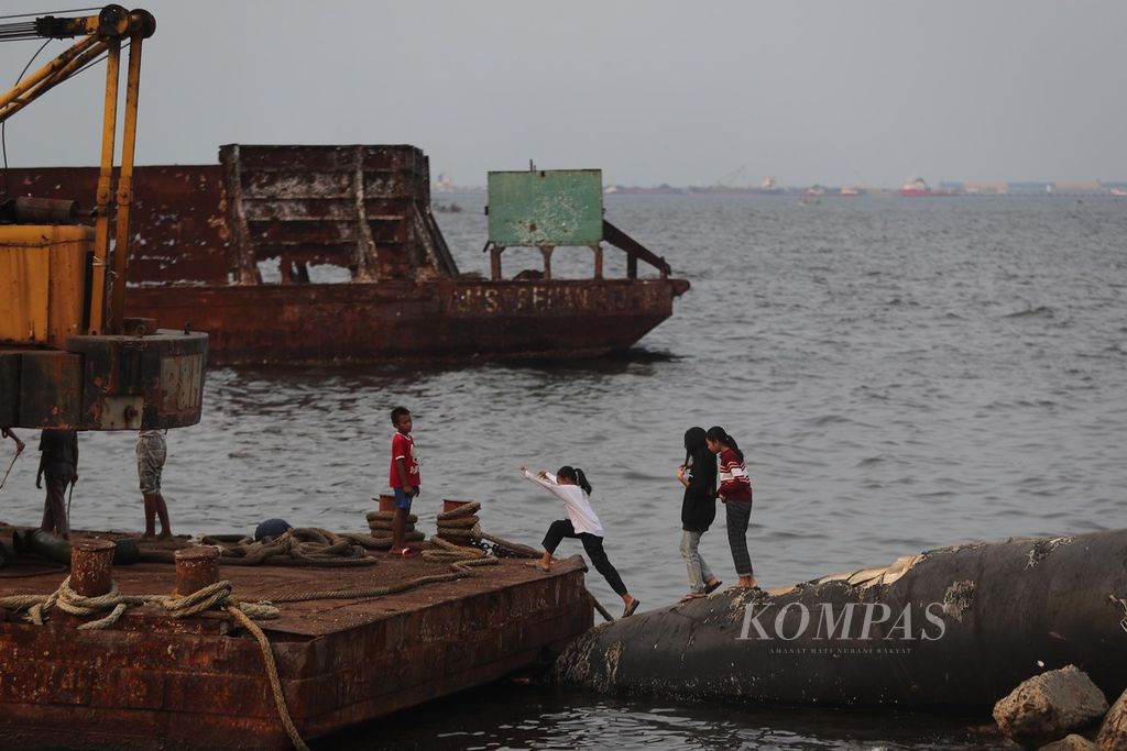  Anak-anak nelayan di Pantai Cilincing, Jakarta Utara, menghabiskan waktu akhir pekannya dengan bermain di pantai, Minggu (6/6/2021). Pemerintah kini fokus menangani kasus gagal ginjal akut pada anak yang bisa berakibat fatal atau kematian.