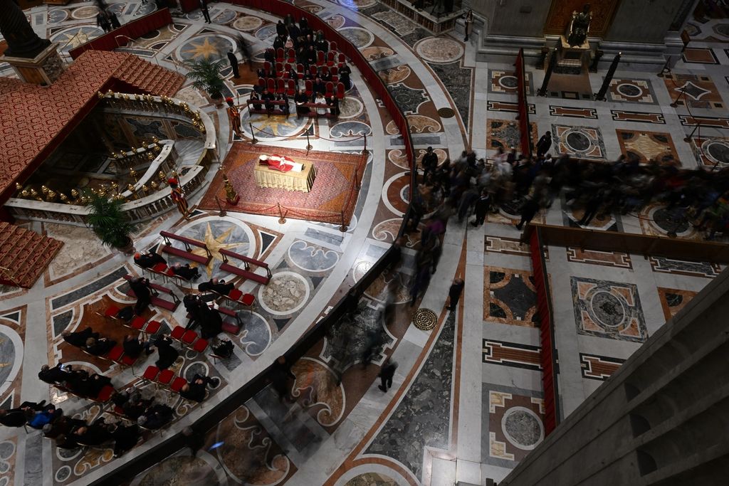 Jenasah Paus Emeritus Benediktus XVI terbaring di Basilika Santo Petrus, Vatikan, Selasa (3/1/2023). Benediktus,  paus pertama dalam enam abad terakhir yang mengundurkan diri dari tahta suci karena alasan kesehatan, meninggal dunia pada 31 Desember 2022 di usia 95 tahun. Misa rekuiem akan diselenggarakan Kamis (5/1/2023). (Photo by Filippo MONTEFORTE / AFP)