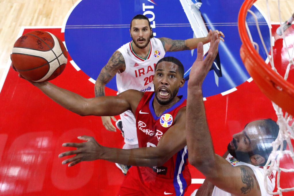 Pemain Puerto Riko, Gary Browne, beraksi saat dibayangi pemain Iran, Hamed Haddadi, di Piala Dunia Bola Basket FIBA, Gimnasium Guangzhou, Guangzhou, China, Sabtu (31/8/2019).