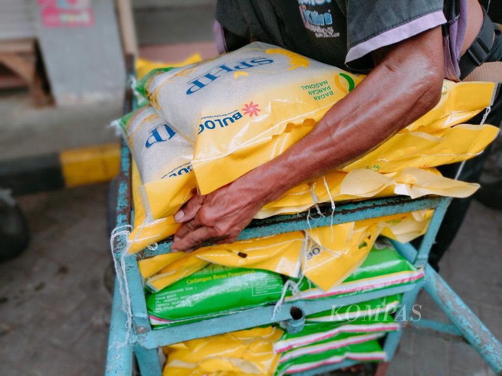 Seorang pekerja mengangkat beras murah dari Bulog untuk dibawa ke salah satu kios di Pasar Rejowinangun, Kota Magelang, Selasa (20/2/2024).