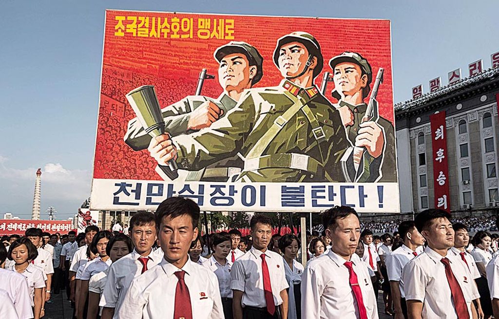 Poster propaganda  terpampang dalam pengerahan massa untuk menyatakan  dukungan terhadap sikap rezim Korea Utara melawan Amerika Serikat di Alun-alun Kim Il Sung, Pyongyang, Korea Utara, Rabu (9/8).