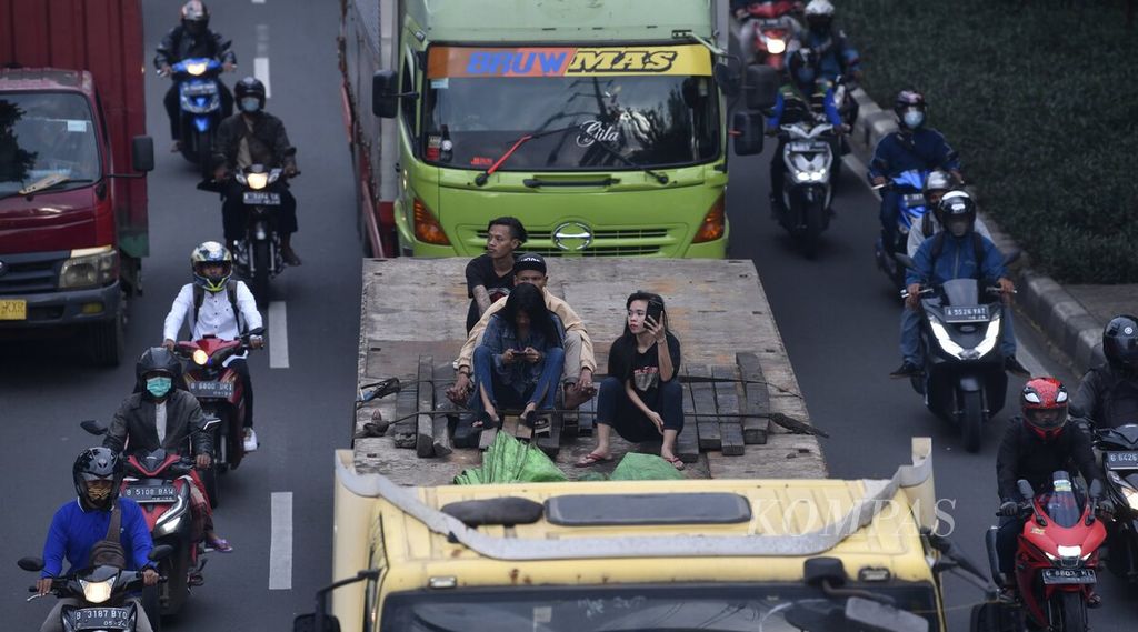 Sejumlah orang yang tidak memakai masker menumpang sebuah truk di kawasan Jalan Daan Mogot, Jakarta Barat, Senin (7/3/2022). Pemerintah menurunkan level pemberlakuan pembatasan kegiatan masyarakat (PPKM) di Jakarta dan wilayah aglomerasi Jabodetabek pada PPKM level dua. Perpanjangan PPKM level dua berlaku selama sepekan mendatang. 