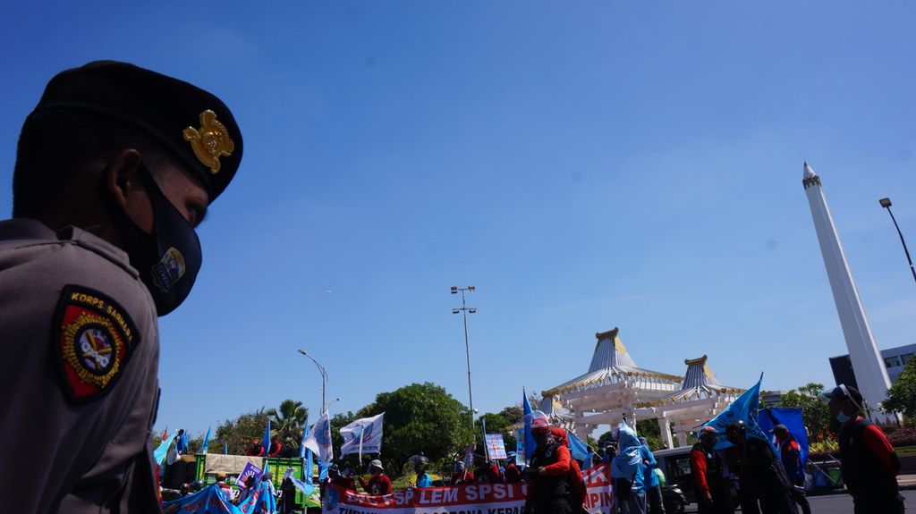 Petugas Polri menjaga situasi demonstrasi buruh menolak RUU Cipta Kerja di depan Kantor Gubernur Jawa Timur, Surabaya, Selasa (28/7/2020).