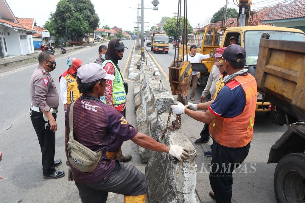 Petugas menutup penggalan jalan atau <i>U-turn</i> dengan <i>barrier </i>beton menjelang Pasar Tegalgubug, Kabupaten Cirebon, Jawa Barat, Senin (18/4/2022). Pemasangan tersebut dilakukan untuk mencegah kemacetan di sekitar pasar saat arus mudik Lebaran 2022.