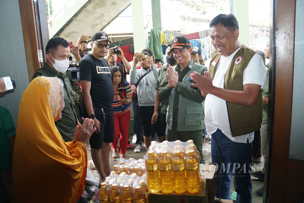 Kepala Badan Nasional Penanggulangan Bencana Suharyanto (kedua dari kanan) didampingi Gubernur Sulawesi Utara Olly Dondokambey (kanan) memberikan bantuan logistik di lokasi pengungsian korban banjir di Kelurahan Molas, di Manado, Sabtu (28/1/2023). 