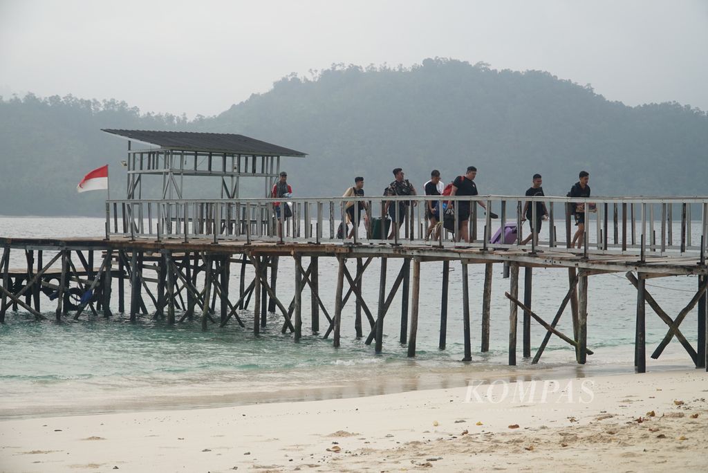 Para pengunjung yang baru tiba berjalan di Dermaga Pulau Sirandah, Kelurahan Teluk Kabung Selatan, Kecamatan Bungus Teluk Kabung, Kota Padang, Sumatra Barat, Minggu (8/10/2023). 