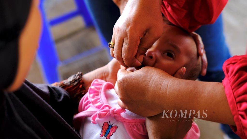 Seorang anak menerima vaksin polio di Posyandu Matius 25, Pondok Karya, Tangerang Selatan, Banten, Minggu (16/6/2019). Posyandu yang dikelola oleh Gereja Santo Matius Penginjil Bintaro ini didirikan pada 2002.