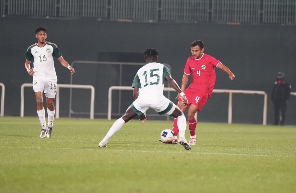 Bek tengah tim U-23 Indonesia, Komang Teguh, menendang bola di tengah hadangan pemain Arab Saudi pada laga uji coba, Sabtu (6/4/2024) dini hari WIB, di Stadion The Sevens, Dubai Uni Emirat Arab. Komang mencetak gol tunggal Indonesia pada laga yang dimenangi Saudi 3-1 itu.