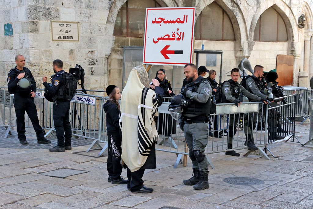 Aparat keamanan Israel menanyai seorang warga di titik pemeriksaan di Kota Tua Jerusalem, Jumat (22/4/2022). Jelang subuh, bentrokan kembali terjadi antara warga Palestina dan aparat keamanan Israel di kompleks Masjid Al Aqsa. 