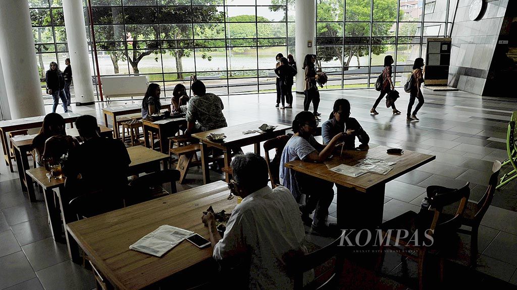 Pengunjung menikmati makanan di resto di tepi danau di kompleks Perpustakaan Pusat Universitas Indonesia, Depok, Rabu (29/3).