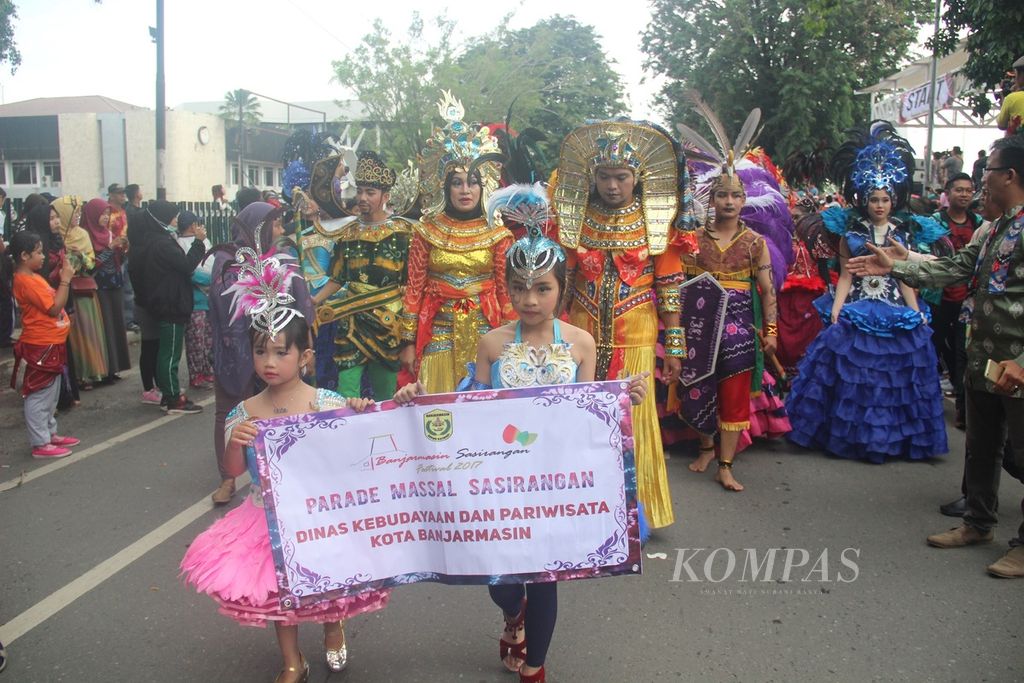 Peserta parade massal sasirangan melintas di Jalan Jenderal Sudirman, Kota Banjarmasin, Kalimantan Selatan, Minggu (19/3/2017). Parade yang diikuti lebih dari 1.000 peserta tersebut digelar pada acara puncak Banjarmasin Sasirangan Festival 2017. 