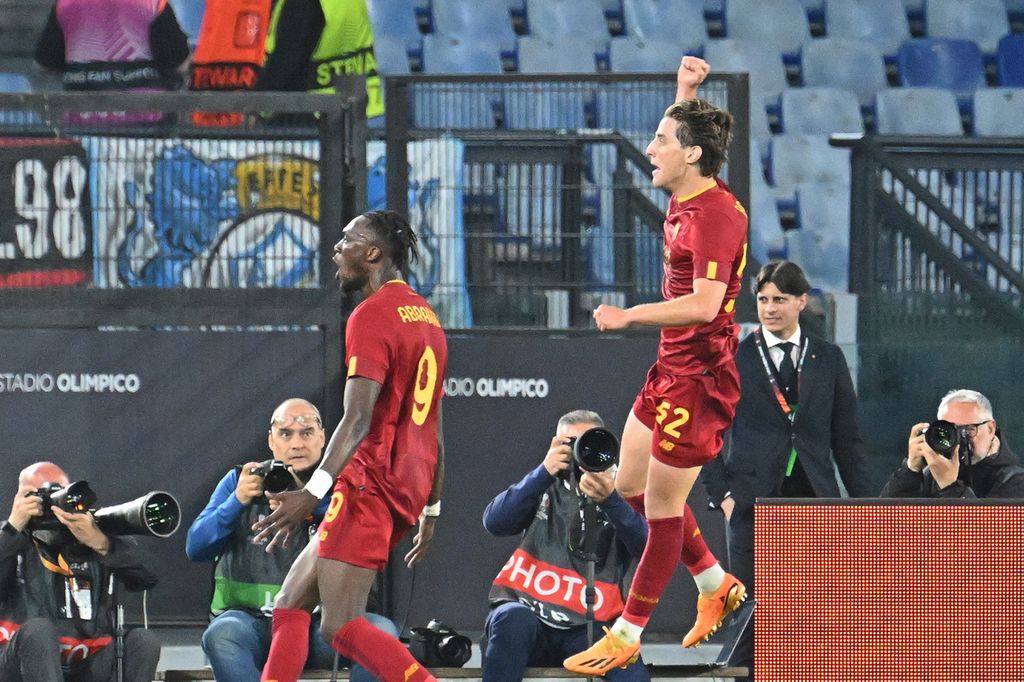 Gelandang AS Roma, Edoardo Bove (kanan), merayakan dengan pemain depan Inggris AS Roma, Tammy Abraham (kanan), setelah mencetak gol pembuka selama pertandingan sepak bola <i>leg</i> pertama semifinal Liga Eropa UEFA antara AS Roma dan Bayer Leverkusen di Stadion Olimpiade, Roma, pada 11 Mei 2023. 