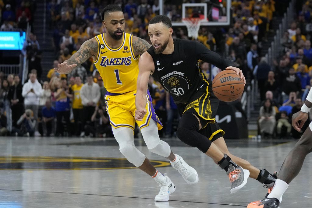 <i>Guard</i> Golden State Warriors, Stephen Curry, menggiring bola di depan <i>guard</i> LA Lakers, DAngelo Russell, saat pertandingan pertama babak semifinal Wilayah Barat <i>playoff</i> NBA antara Warriors dan LA Lakers di Chase Center, San Francisco, Rabu (3/5/2023) WIB. 