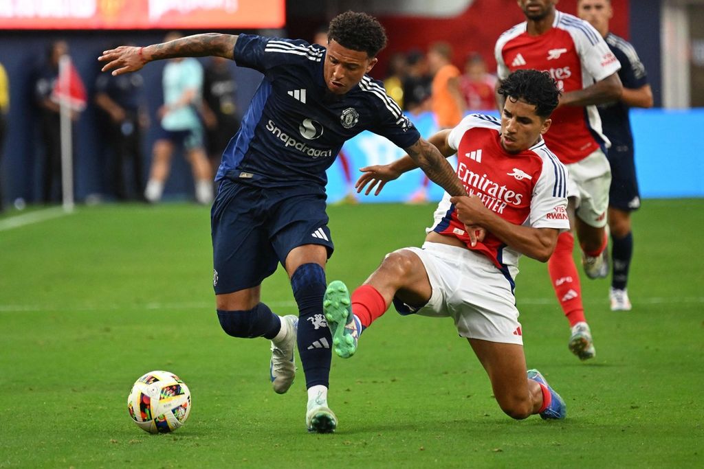 Pemain Manchester United, Jadon Sancho, dan pemain Arsenal, Salah-Eddine Oulad M’Hand, berebut bola dalam pertandingan persahabatan antara MU dan Arsenal di Stadion SoFi, Inglewood, California, Sabtu (27/7/2024). Sancho dipinjamkan ke Chelsea.