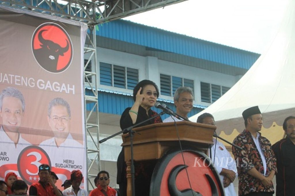 Ketua Umum PDP-P Megawati Soekanoputri saat memberikan orasi politik dalam kampanye terakhir pemilihan kepala daerah Jawa Tengah di hadapan belasan ribu kader dan simpatisannya di GOR Satria, Kabupaten Banyumas. Pada Pilkada Jateng 2013, PDI-P mengusung pasangan calon Ganjar Pranowo (keempat dari kanan) berdampingan dengan Heru Sudjatmoko (ketiga dari kanan). 