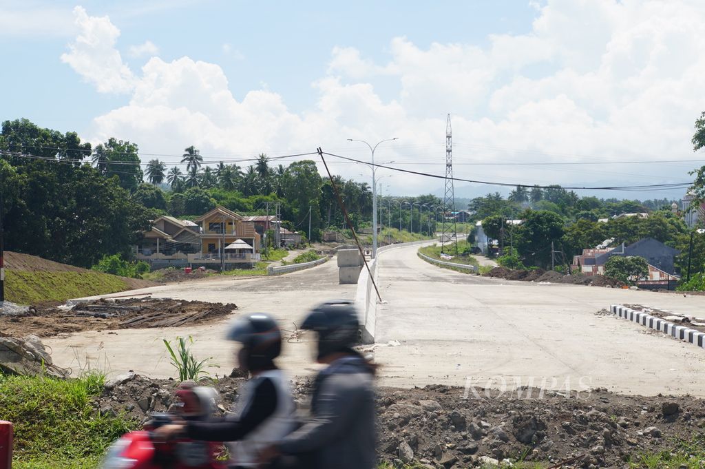 Warga melintas di ujung Jalan Tol Manado-Bitung di Kelurahan Sagerat, Bitung, Sulawesi Utara, tepat di seberang Kawasan Ekonomi Khusus (KEK) Bitung, Jumat (17/7/2020).