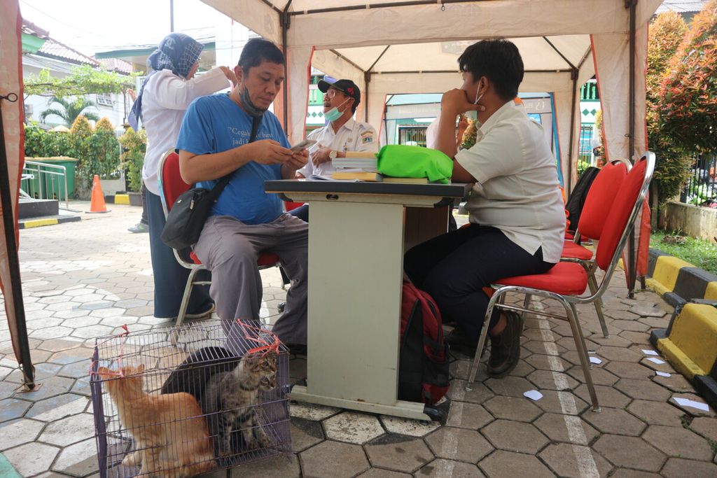 Seorang warga sedang mendaftar agar kucing-kucingnya divaksin rabies. Kegiatan vaksinasi ini dilakukan di Kantor Kelurahan Pancoran, Jakarta Selatan, Rabu (9/11/2022).