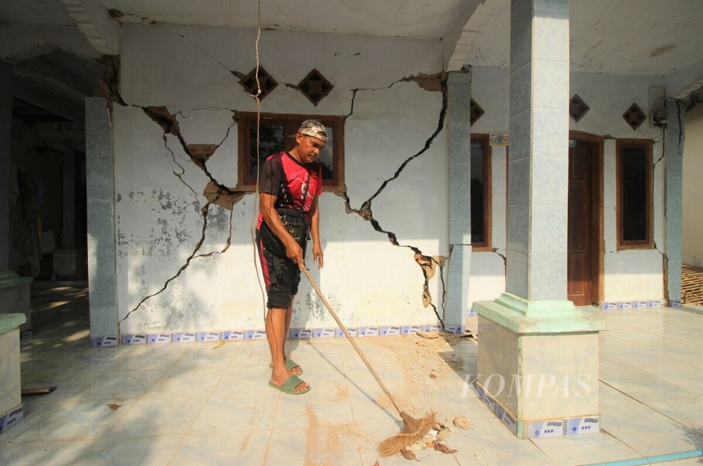 Warga membersihkan rumahnya di Desa Tamanjaya, Kecamatan Sumur, Kabupaten Pandeglang, Banten, Sabtu (15/1/2022), yang rusak diguncang gempa bermagnitudo 6,6 pada sehari sebelumnya.