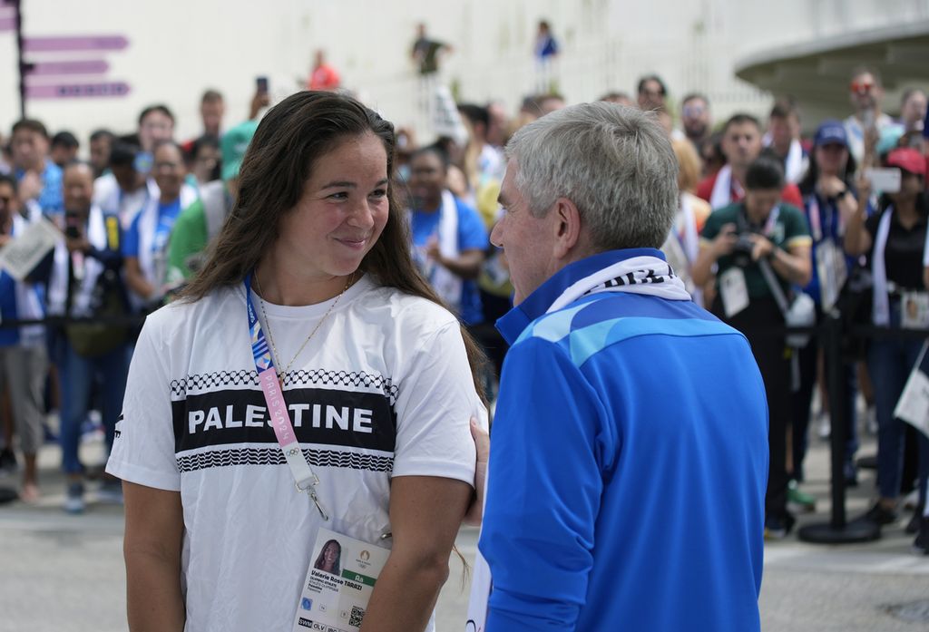 Presiden Komite Olimpiade Internasional (IOC) Thomas Bach berbincang dengan atlet Palestina Valerie Rose Tarazi, kiri, setelah Tarazi menandatangani Monumen Damai di perkampungan atlet Olipiade Paris 2024 di Paris, Perancis, Senin (22/7/2024). 