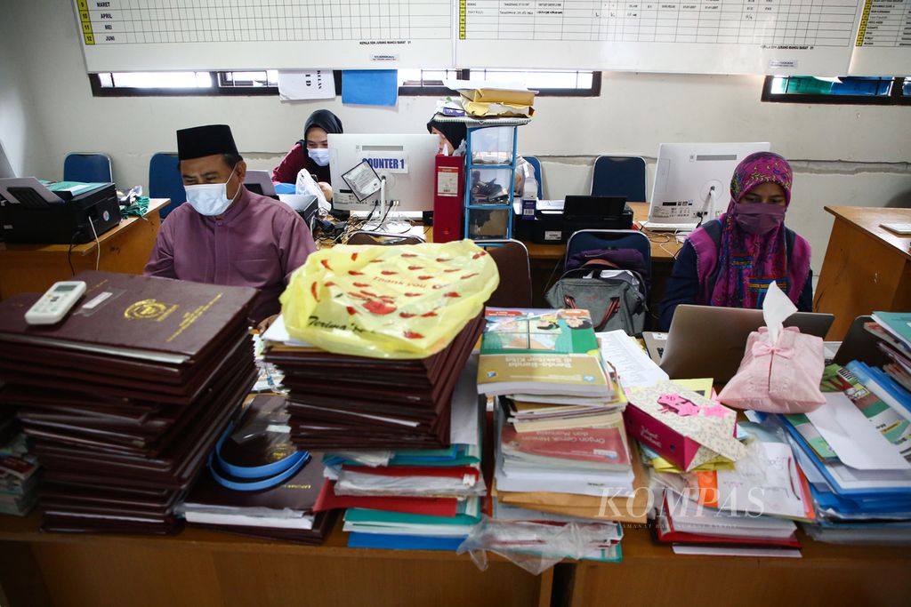 Syukron (kiri), guru agama Islam bagi siswa kelas lima dan enam, mempersiapkan bahan penilaian harian yang akan diunggah ke platform pembelajaran jarak jauh Google Form di SD Negeri Jurang Mangu Barat 01, Tangerang Selatan, Banten, Jumat (29/1/2021). 