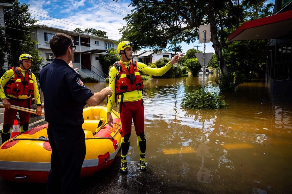 Petugas dari Dinas Pemadam Kebakaran dan SAR tengah bersiap di tepi jalan yang tergenang banjir di wilayah Paddington, Brisbane pada Senin (28/2/2022).