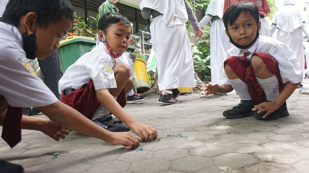 Grade 1 students play marbles at SD Negeri Mojo 3, Surabaya, East Java, Wednesday (21/9/2022). Since April 2018, Mojo 3 Elementary School has declared itself as an educational institution for the preservation of traditional games. 